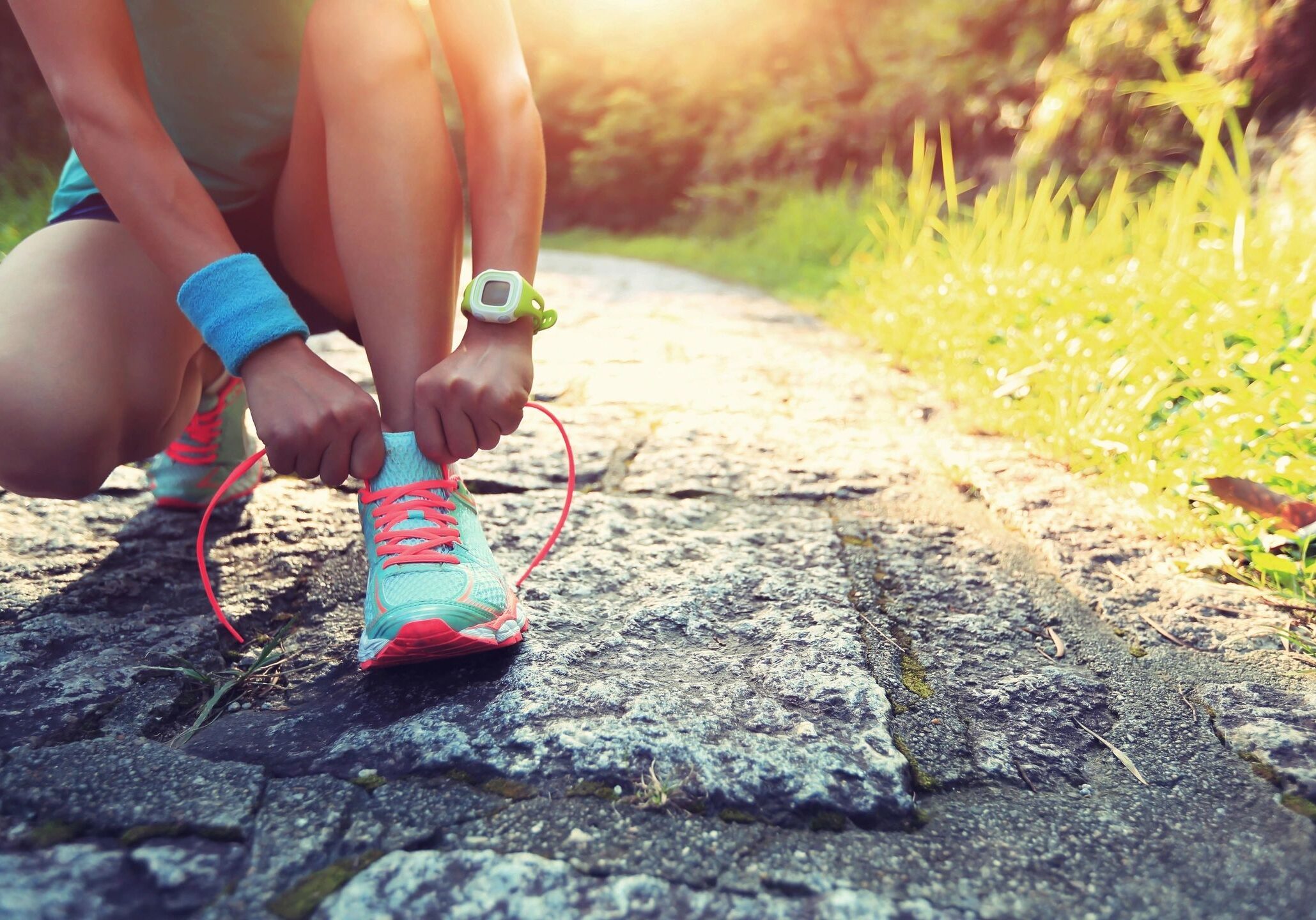 Runner tying shoelaces on trail